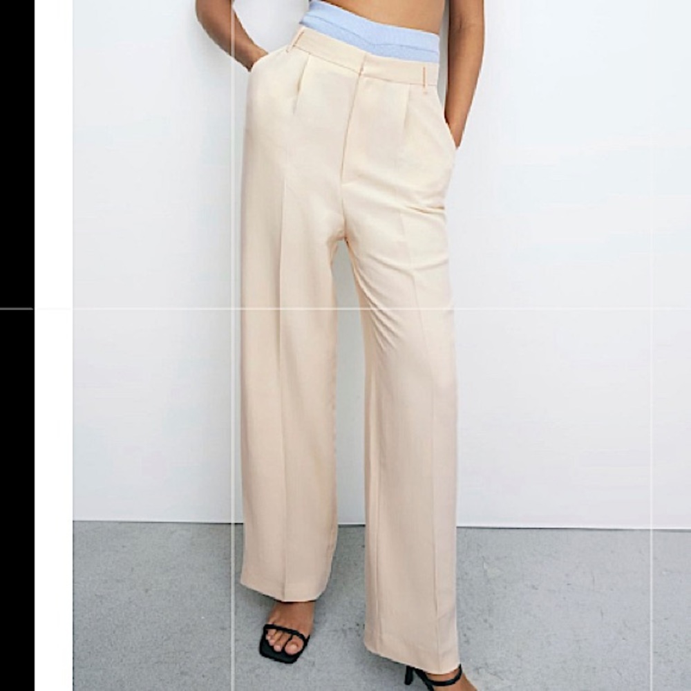 Cream high waisted pants with wide legs.